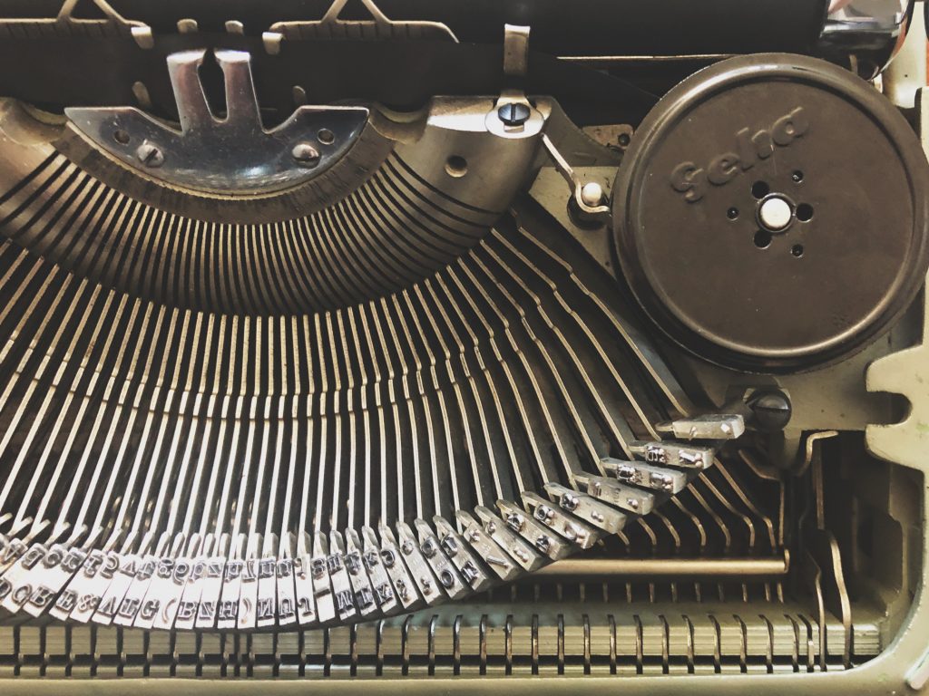 The inside mechanics of a vintage typewroter, keys and ribbon spool.